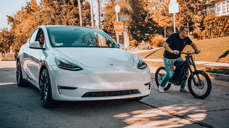 Image 1 : Une Tesla Model Y fait la course avec un vélo électrique