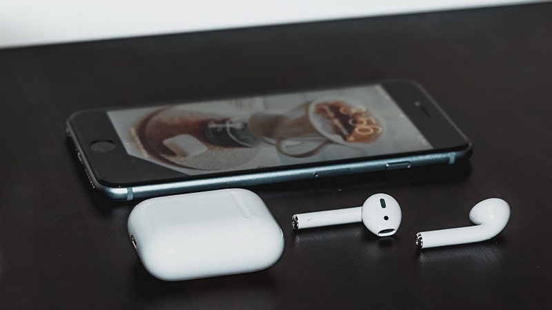 AirPods posés à côté d'un iPhone