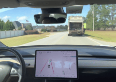 Une Tesla dépasse un camion poubelle