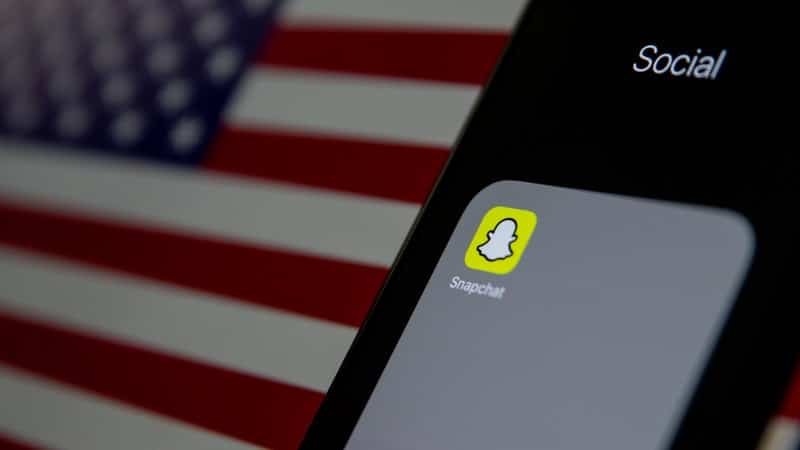 Le logo Snapchat avec le drapeau des États-Unis en arrière-plan