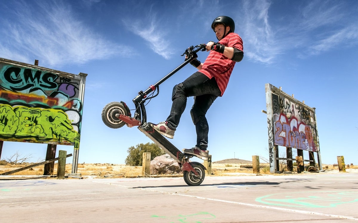 Homme cabrant en trottinette électrique