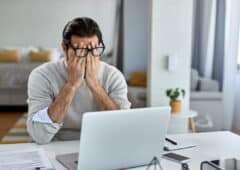 Tired male entrepreneur working on a computer at home.