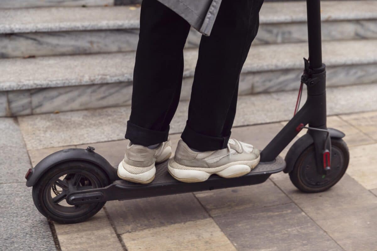 Un homme conduisant son scooter électrique à l'extérieur