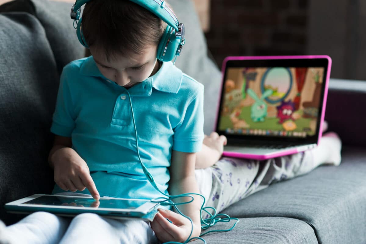 Un enfant regardant des dessins animés sur l'écran de sa tablette 