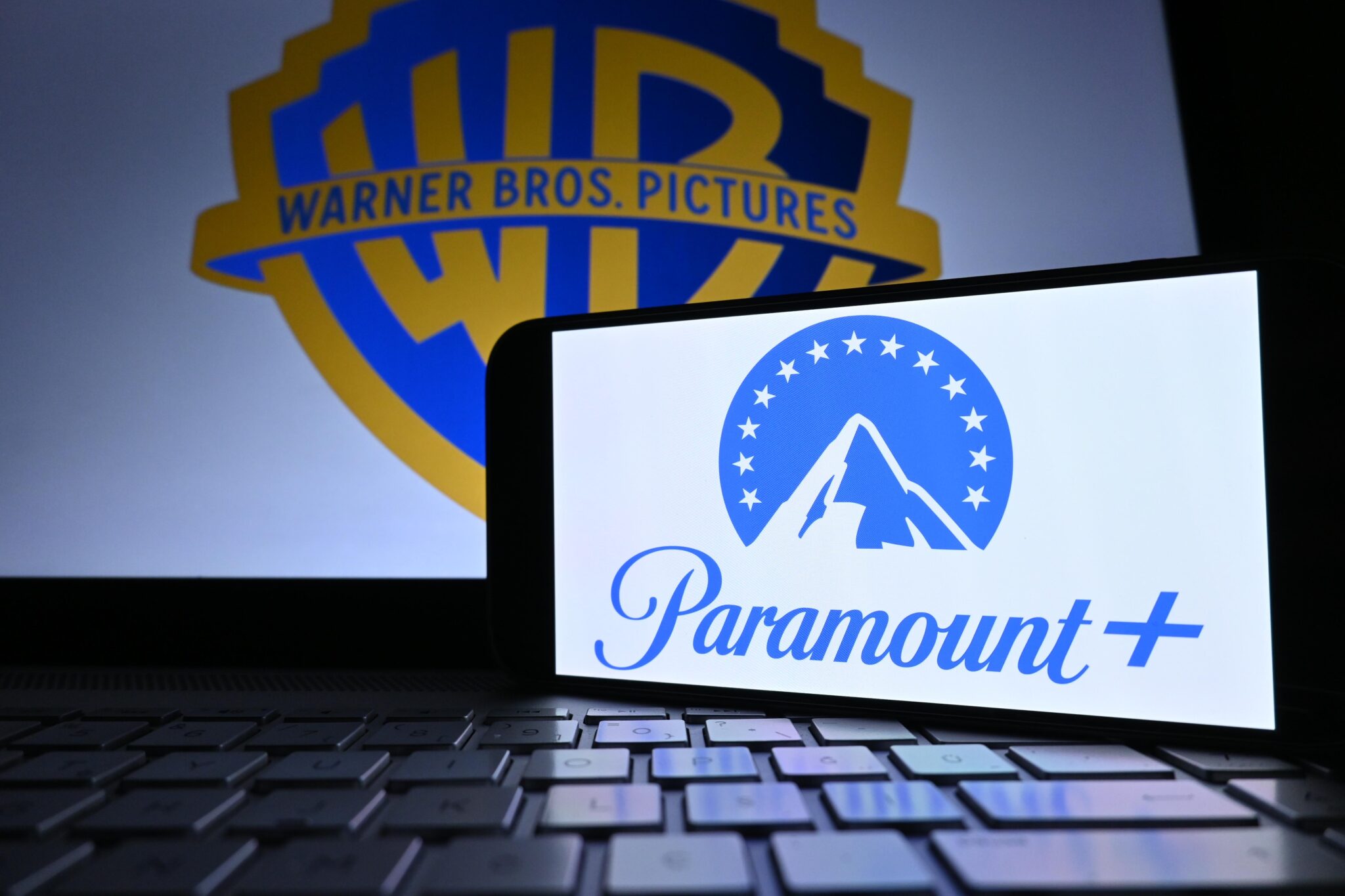 Le logo de Paramount+ devant celui de Warner Bros., alors que les actionnaires de WBD viennent de valider le rachat pour 111 milliards de dollars.