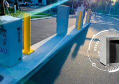 La caméra Survision NanoPak, ici intégrée à une entrée de parking avec barrière automatique. Ce boîtier compact (visible en médaillon à droite) lit les plaques en temps réel, sans ticket ni déclencheur. © Survision