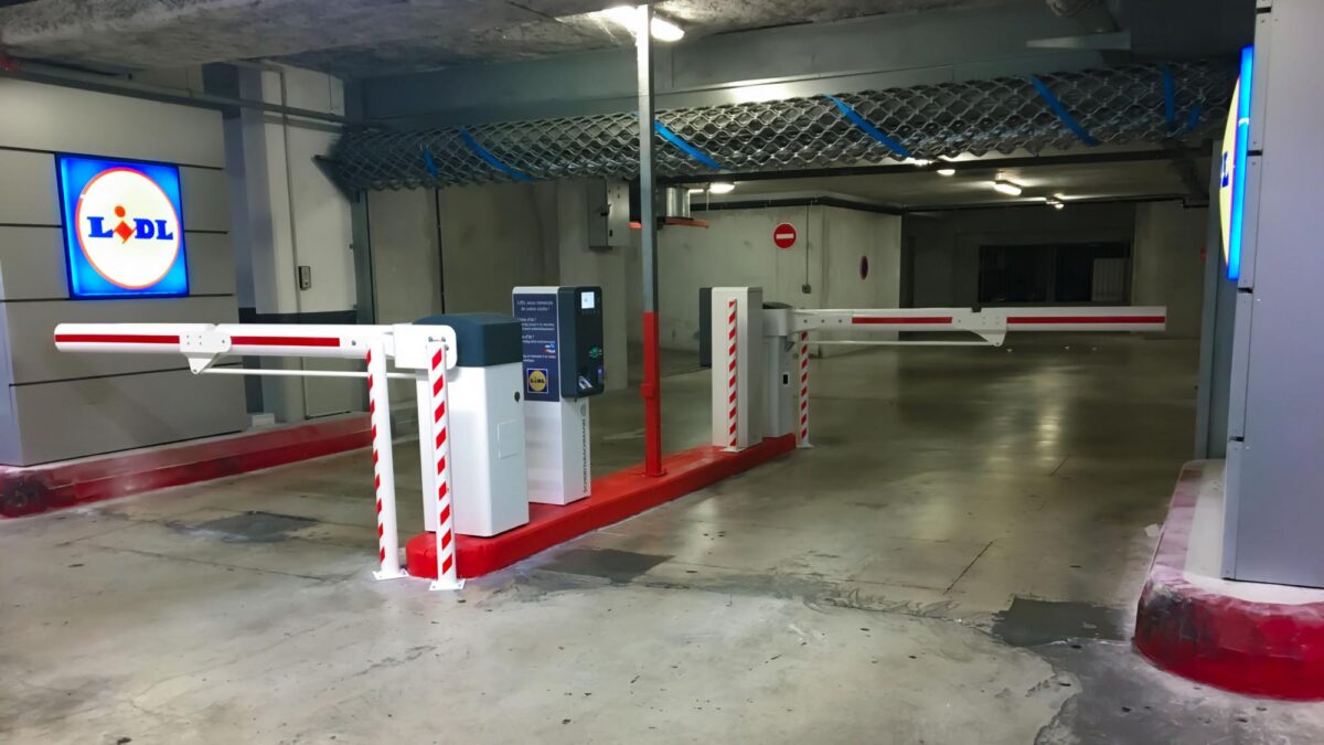 Le parking souterrain du Lidl de Nice, équipé de barrières et de caméras LAPI Survision NanoPak. La borne centrale (en noir) intègre le lecteur de plaque : aucun ticket à retirer, la barrière s'ouvre après reconnaissance automatique. © Survision
