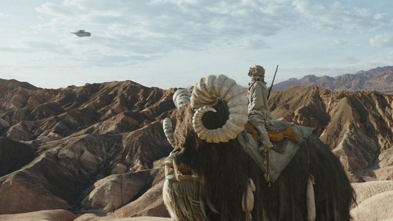 Le Razor Crest volant au-dessus d'une planète ressemblant à Tatooine